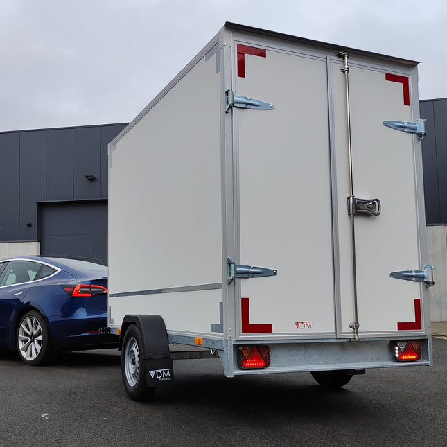 Een aanhangwagen enkelas met witte panelen en voorzien van LED verlichting. De 2 achterlichten zijn LED met ingebouwde LED nummerplaat verlichting. De achterlicht units zijn Fristom FT-270 lampen links en rechts. De linkse unit heeft een mistachterlicht, de rechtse unit heeft een achteruitrijlicht.