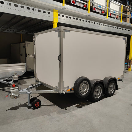 Gesloten dubbelas merk VDM Trailer afmeting 300x150cm dubbelas uitvoering met gemonteerd reservewiel op een reservewielsteun (houder) en op de dissel een gemonteerd neuswiel met dubbele off-road banden.