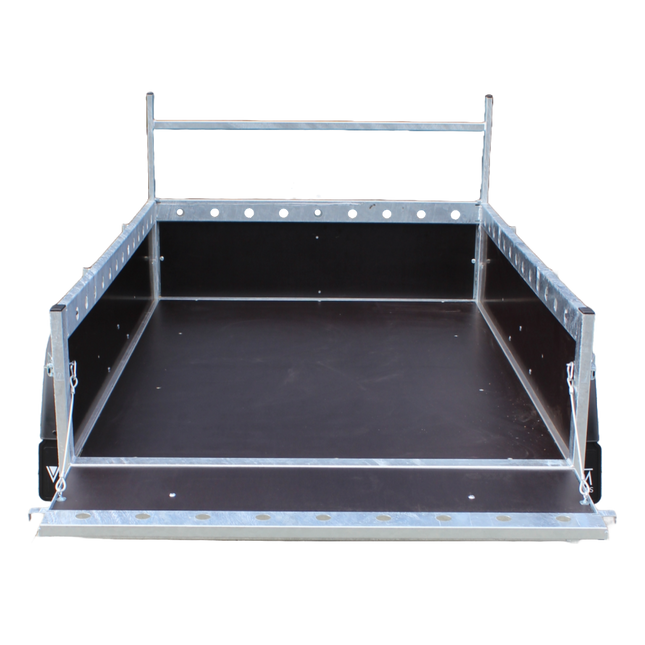 Een open bakwagen enkelas uitvoering met opengeklapte laadklep en voorzien van valtouwen aan het achterbord. Het chassis is van VDM Trailers en voorzien van geponste gaten in de profielen bovenaan. Vooraan is een ladderrek gemonteerd om planken op te leggen.